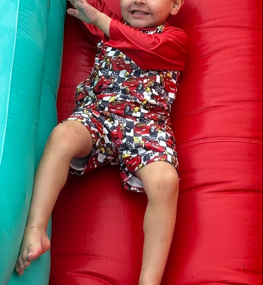 Child sliding down a colorful inflatable slide with red, yellow, and blue sections.